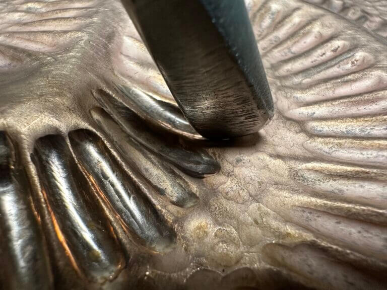 chasing tool on copper sheet close up